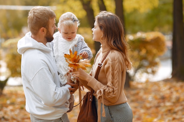 Familia con hija pequeña en un parque de otoño