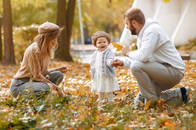 Familia con hija pequeña en un parque de otoño