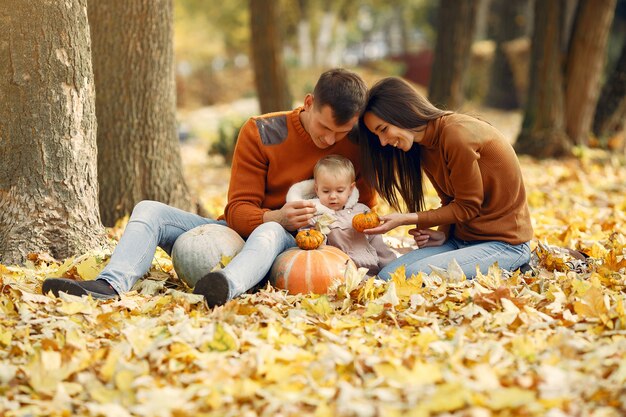 Familia con hija pequeña en un parque de otoño