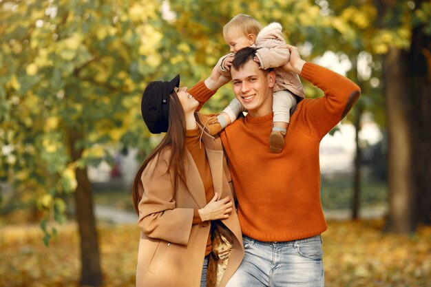 Familia con hija pequeña en un parque de otoño