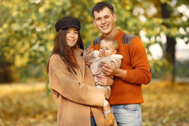 Familia con hija pequeña en un parque de otoño