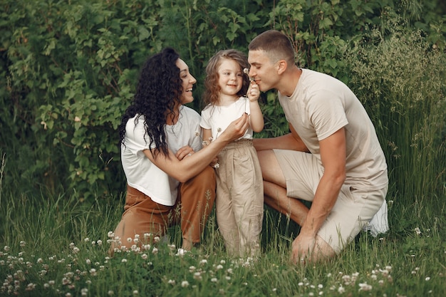 Familia con hija pequeña pasar tiempo juntos en campo soleado