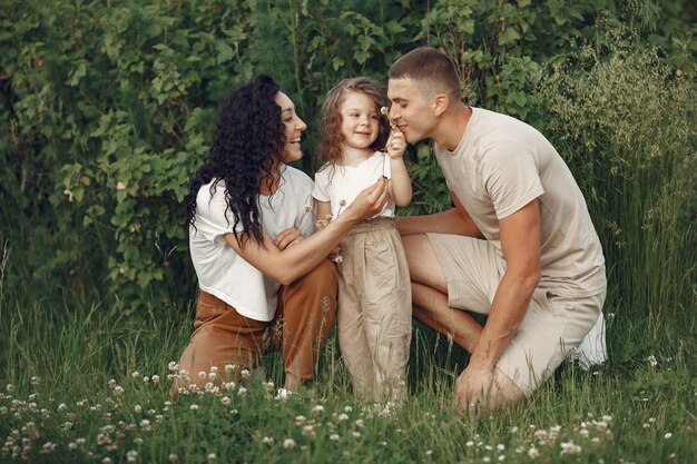 Familia con hija pequeña pasar tiempo juntos en campo soleado