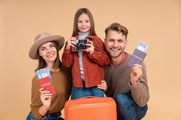 Familia con hija sosteniendo pasaportes y equipaje listo para viajar