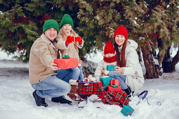 Familia con hijas lindas en un parque de invierno