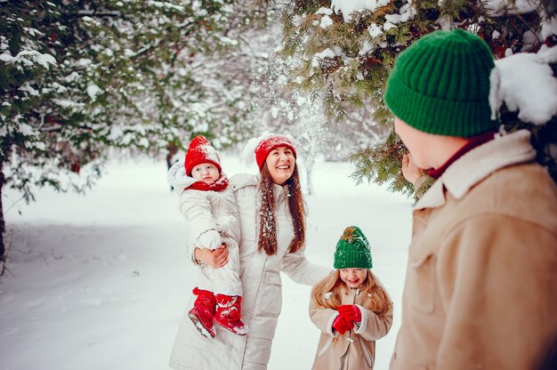 Familia con hijas lindas en un parque de invierno