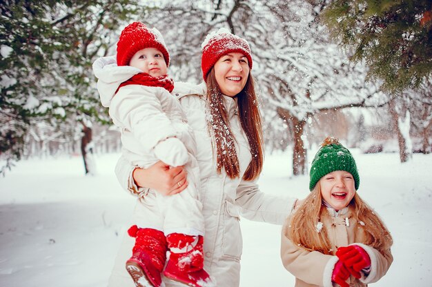 Familia con hijas lindas en un parque de invierno