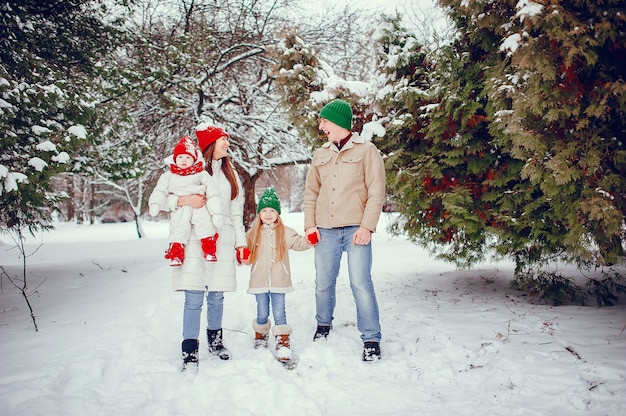 Familia con hijas lindas en un parque de invierno