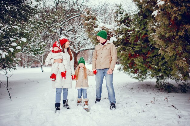 Familia con hijas lindas en un parque de invierno