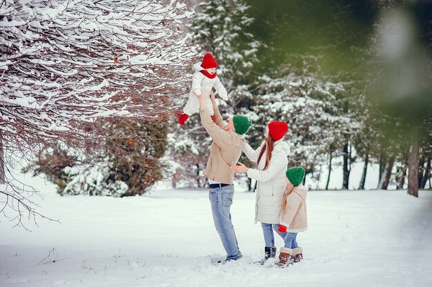 Familia con hijas lindas en un parque de invierno