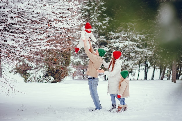 Familia con hijas lindas en un parque de invierno