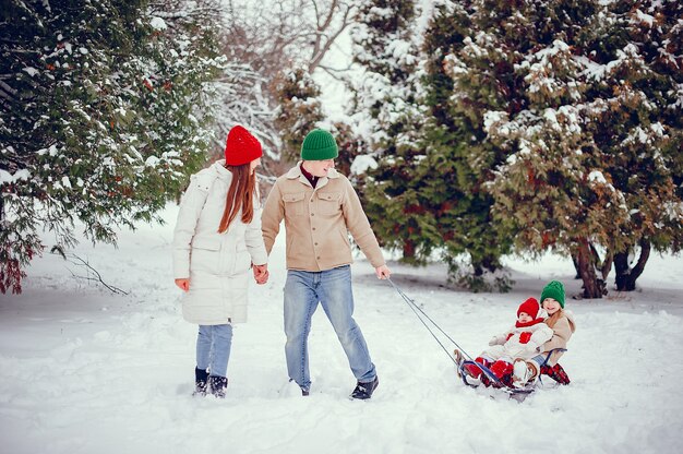 Familia con hijas lindas en un parque de invierno