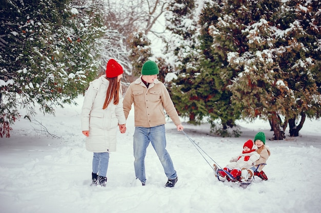 Familia con hijas lindas en un parque de invierno