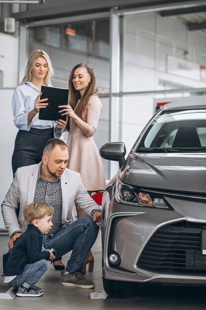 Familia con hijo elegir un coche en una sala de exposición de coches