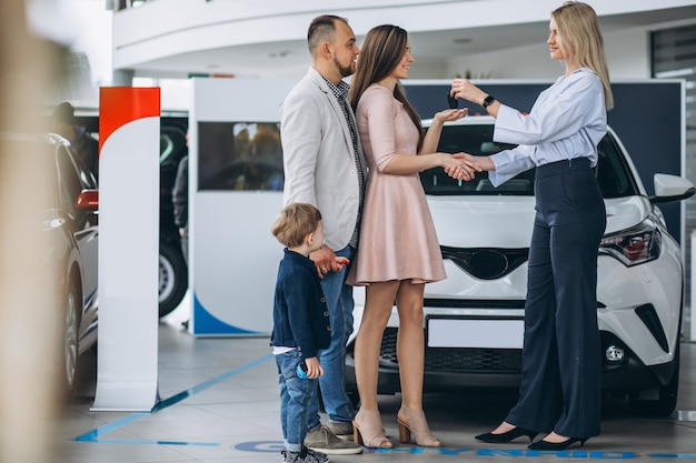 Familia con hijo elegir un coche en una sala de exposición de coches