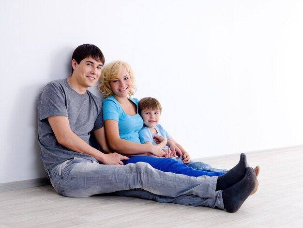 Familia con hijo en habitación vacía