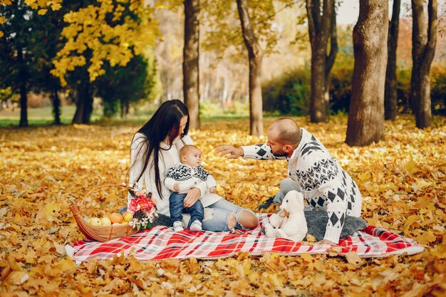 Familia con hijo en un parque de otoño