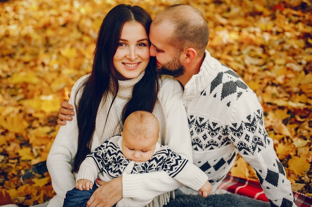 Familia con hijo en un parque de otoño