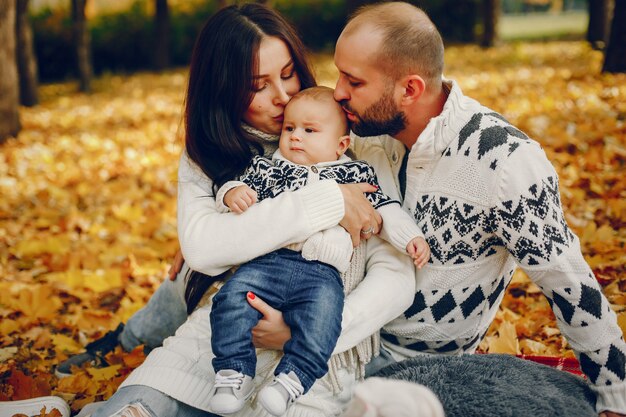 Familia con hijo en un parque de otoño