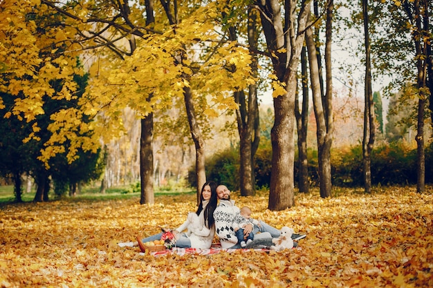 Familia con hijo en un parque de otoño