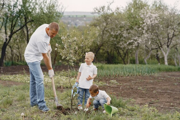 Familia con hijos pequeños están plantando un árbol en un patio