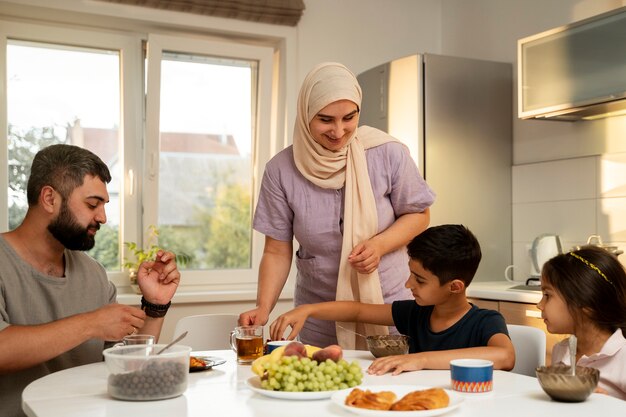 Familia islámica sonriente de tiro medio en casa