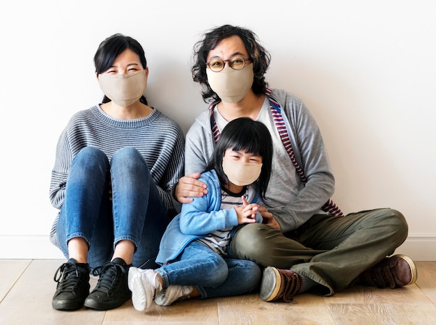 Familia japonesa con máscaras faciales dentro de la casa