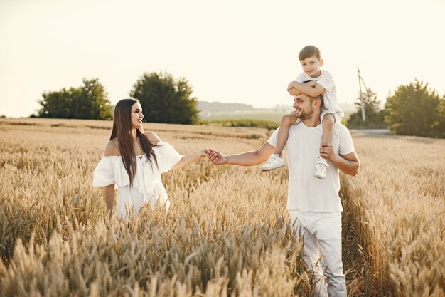 Familia joven en el campo de trigo en un día soleado.