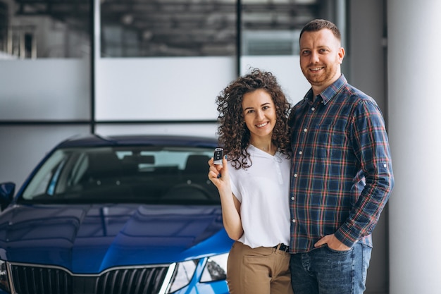 Familia joven comprando un automóvil en una sala de exposición de automóviles