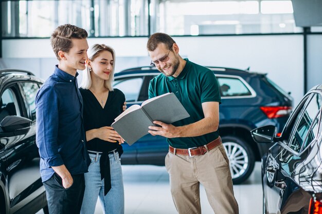 Familia joven comprando un automóvil en una sala de exposición de automóviles