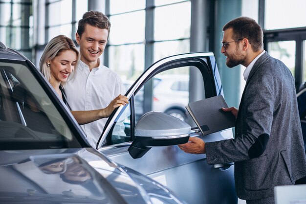 Familia joven comprando un automóvil en una sala de exposición de automóviles