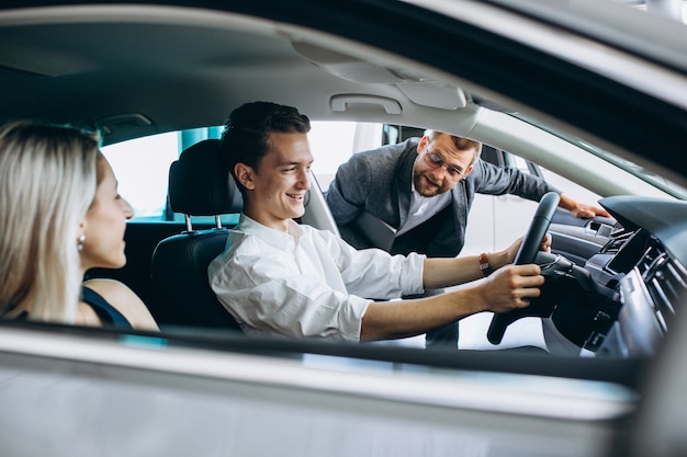 Familia joven comprando un automóvil en una sala de exposición de automóviles