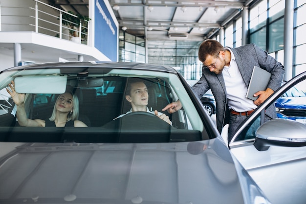 Familia joven comprando un automóvil en una sala de exposición de automóviles