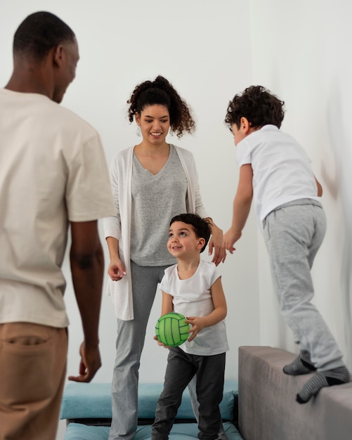 Foto gratuita familia joven divirtiéndose mientras juega con la pelota