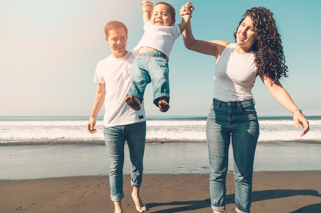 Familia joven divirtiéndose en la playa