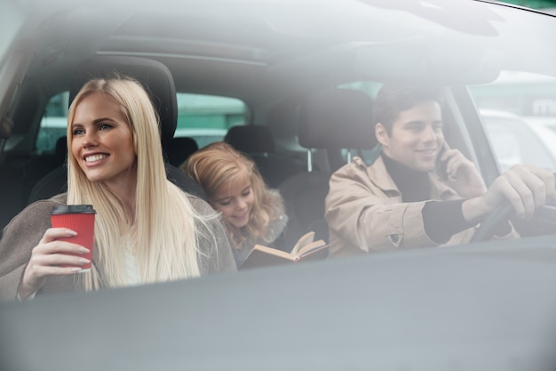 Familia joven feliz en auto