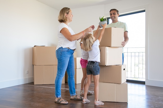 Familia joven feliz con cajas de mudanza en su nueva casa