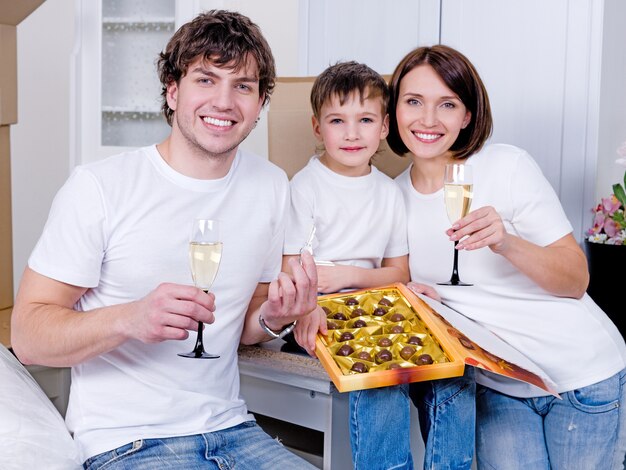 Familia joven feliz celebrando juntos el nuevo hogar - en el interior