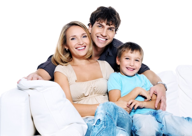 Foto gratuita familia joven feliz con niño emplazamiento en sofá blanco aislado