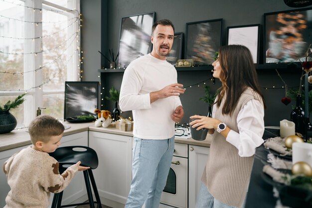 Familia joven feliz pasar tiempo juntos en la cocina en casa en Navidad