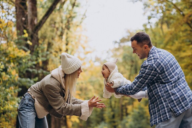 Familia joven con hija pequeña en el parque otoño