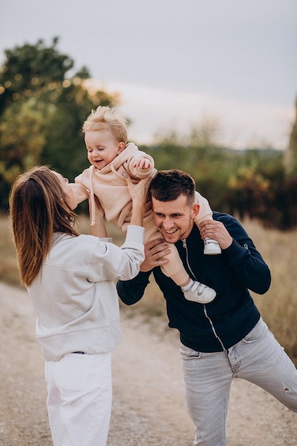 Foto gratuita familia joven con hijo pequeño en el parque