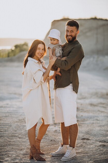 Familia joven con hijo pequeño en la puesta de sol