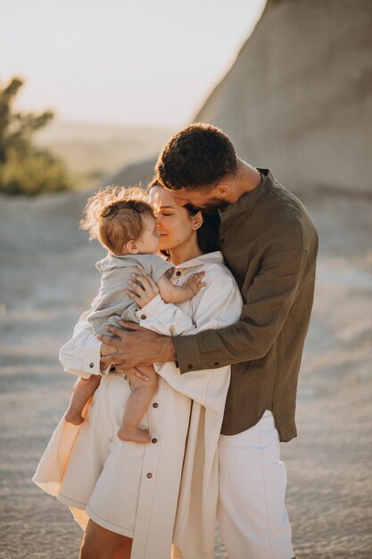 Familia joven con hijo pequeño en la puesta de sol