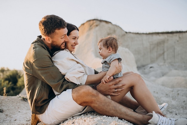 Foto gratuita familia joven con hijo pequeño en la puesta de sol