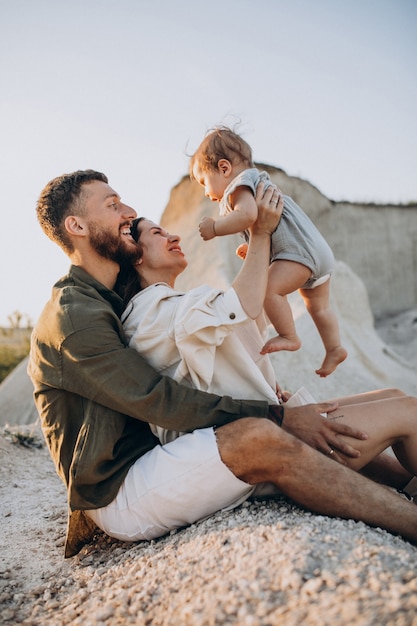 Foto gratuita familia joven con hijo pequeño en la puesta de sol