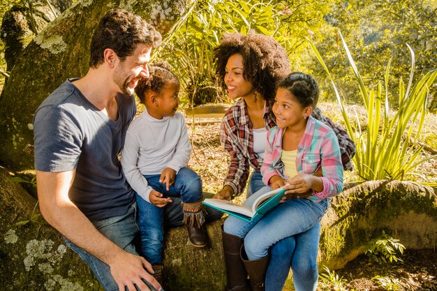 Familia jovén juntos debajo de un árbol