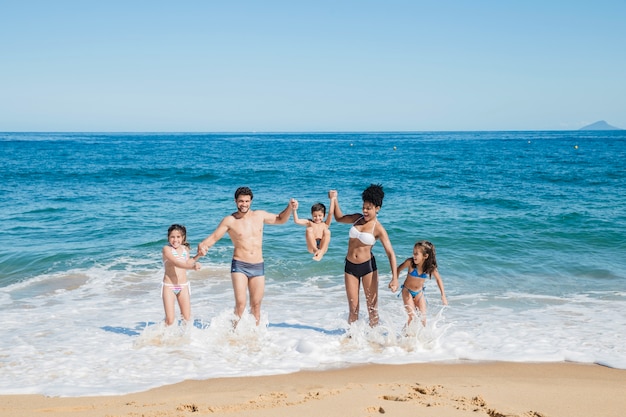 Familia joven por la orilla