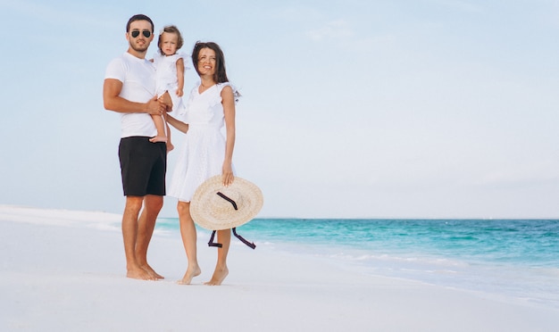 Foto gratuita familia joven con pequeña hija en vacaciones junto al mar