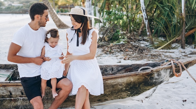 Familia joven con pequeña hija en vacaciones junto al mar